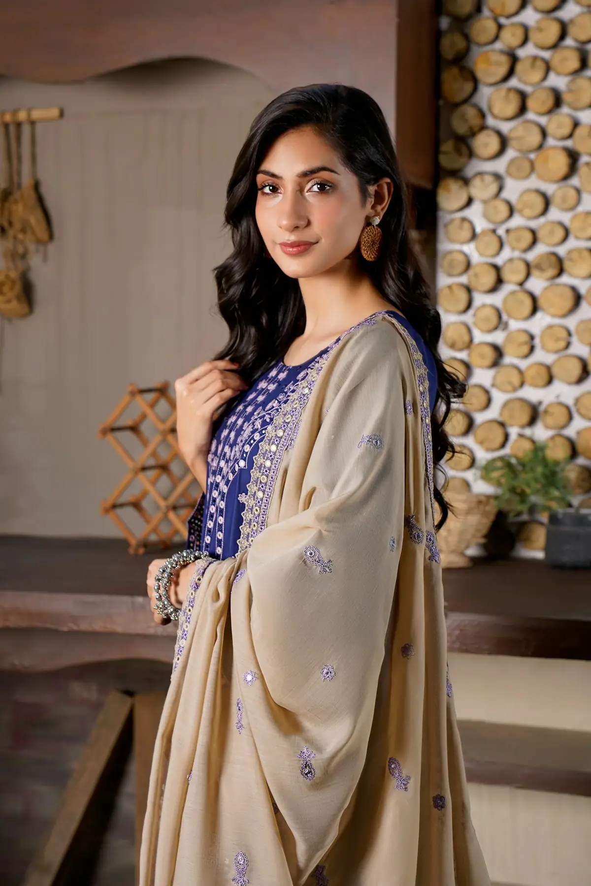 Woman wearing a blue embroidered dress and shawl