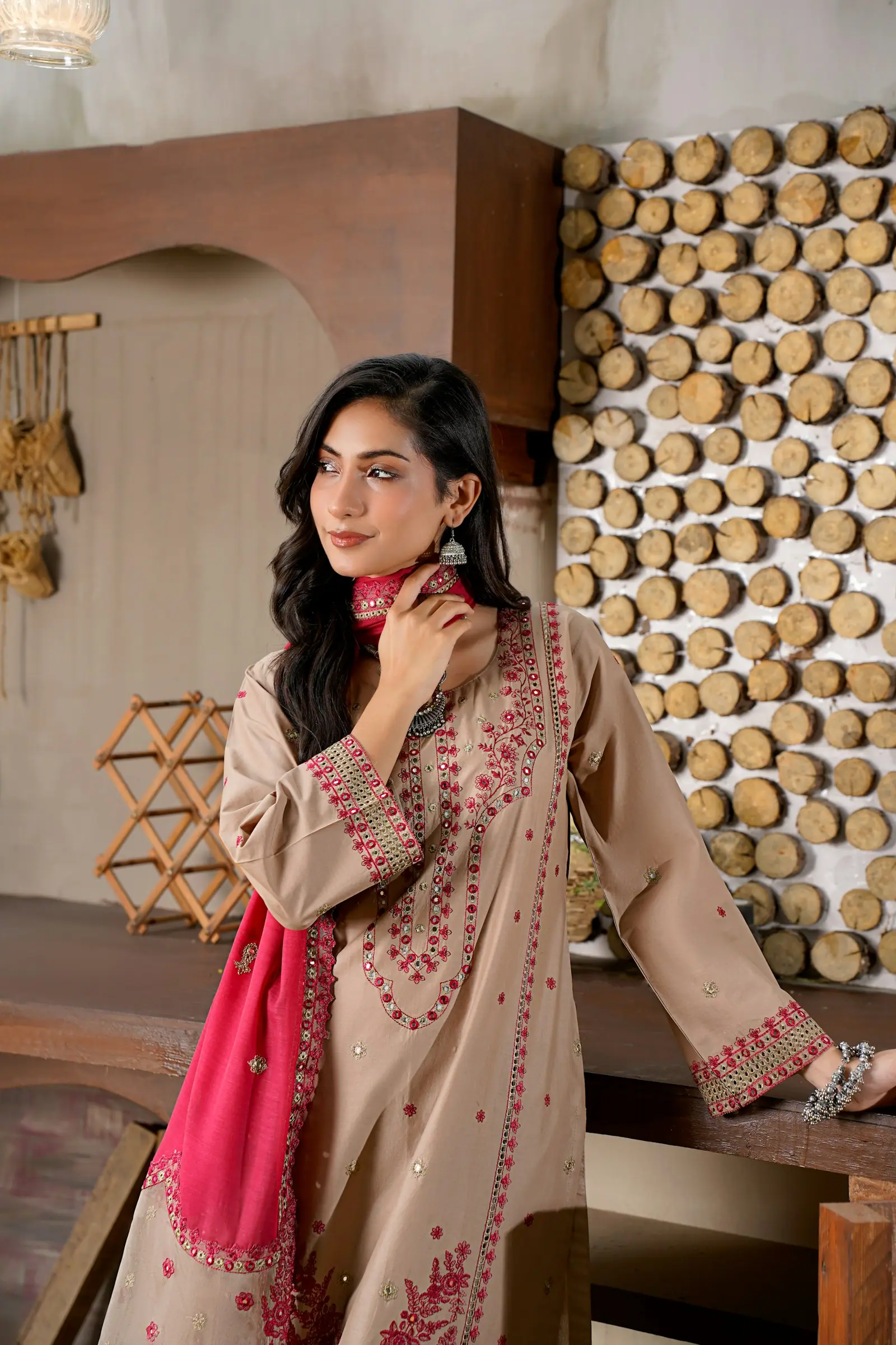 Woman in a taupe embroidered Pakistani suit with a pink dupatta